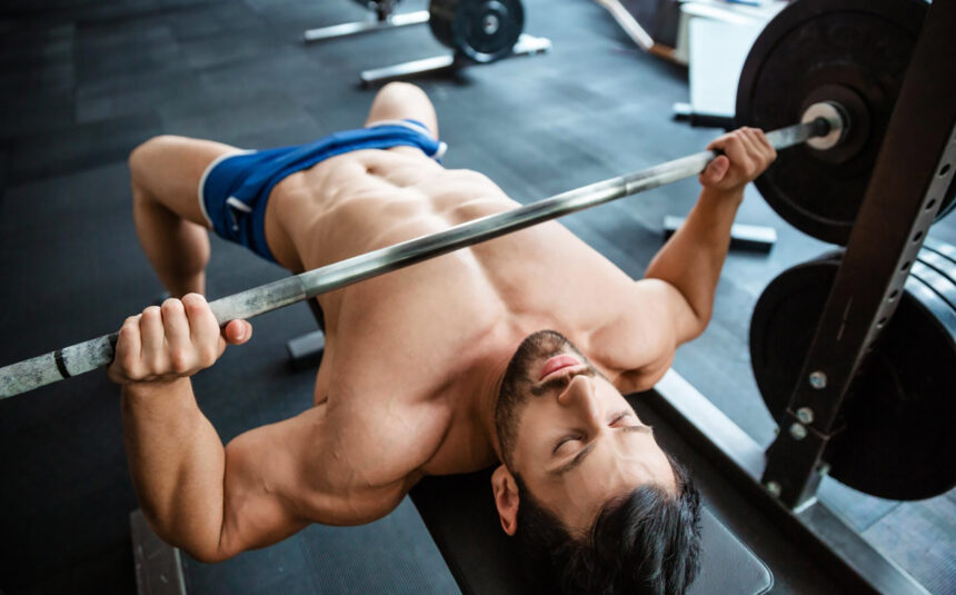 how to perform the bench press | man doing bench press in gym